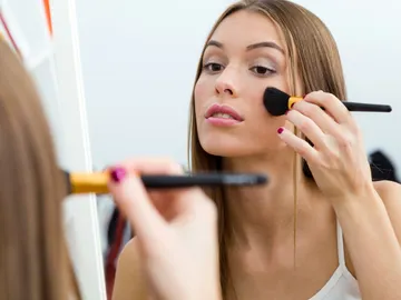 Mujer maquillándose Mujer maquillándose