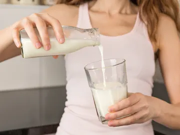 Mujer tomándose un vaso de leche Mujer tomándose un vaso de leche