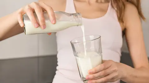 Mujer tomándose un vaso de leche Mujer tomándose un vaso de leche