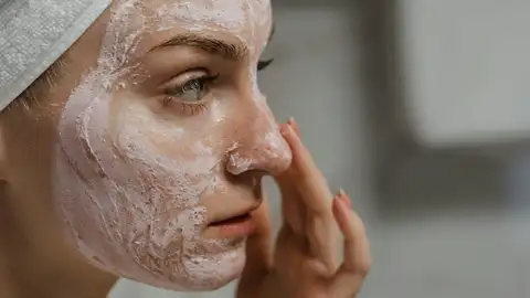 Mujer aplicándose una mascarilla Mujer aplicándose una mascarilla