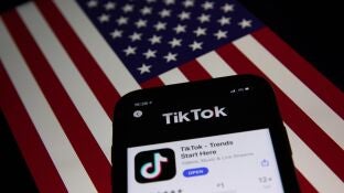 La aplicaci&oacute;n TIkTok sobre una bandera de EEUU