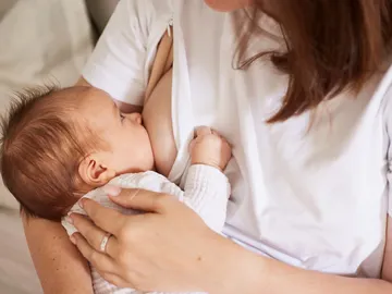 Una mujer da el pecho a su bebé Una mujer da el pecho a su bebé