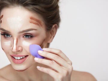Mujer utilizando esponja de maquillaje