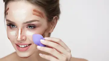 Mujer utilizando esponja de maquillaje Mujer utilizando esponja de maquillaje