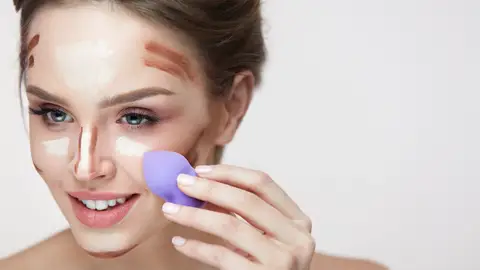 Mujer utilizando esponja de maquillaje Mujer utilizando esponja de maquillaje