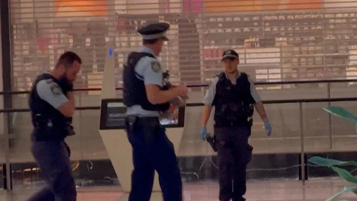 Oficiales de policía caminan junto al cuerpo del atacante que mató a varias personas con un cuchillo en Sidney Oficiales de policía caminan junto al cuerpo del atacante que mató a varias personas con un cuchillo en Sidney