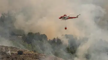 Un helicóptero de los Servicios de Emergencia trabaja en la extinción del incendio forestal de Tárbena