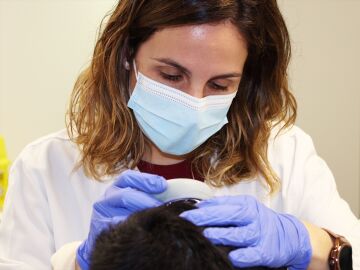 Una dermatóloga revisa el cuero cabelludo