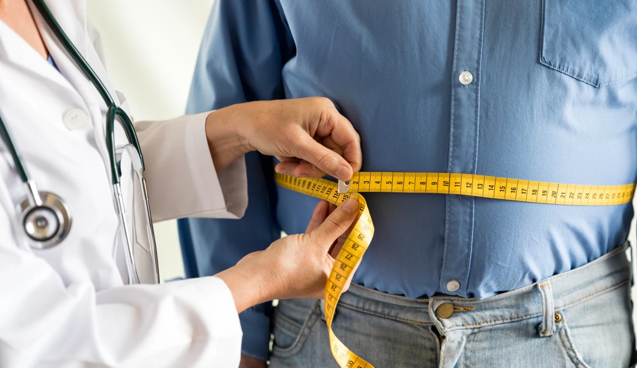 Un médico mide el sobrepeso de un paciente