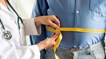 Un médico mide el sobrepeso de un paciente