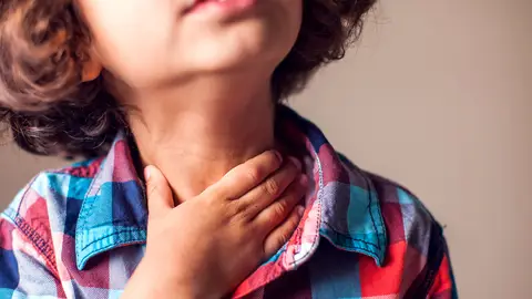 Un niño con dolor de garganta Un niño con dolor de garganta