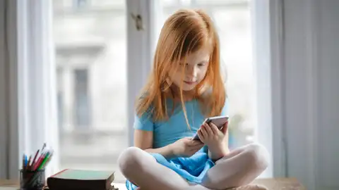 Niña con un móvil Niña con un móvil