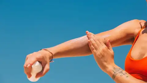 Una mujer aplicándose crema solar Una mujer aplicándose crema solar