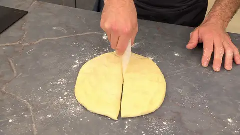 Aplasta la masa un poco para quitarle el aire y córtala en 4 trozos Aplasta la masa un poco para quitarle el aire y córtala en 4 trozos