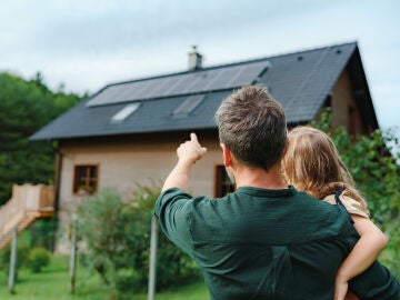 Un padre y una hija miran una vivienda por fuera
