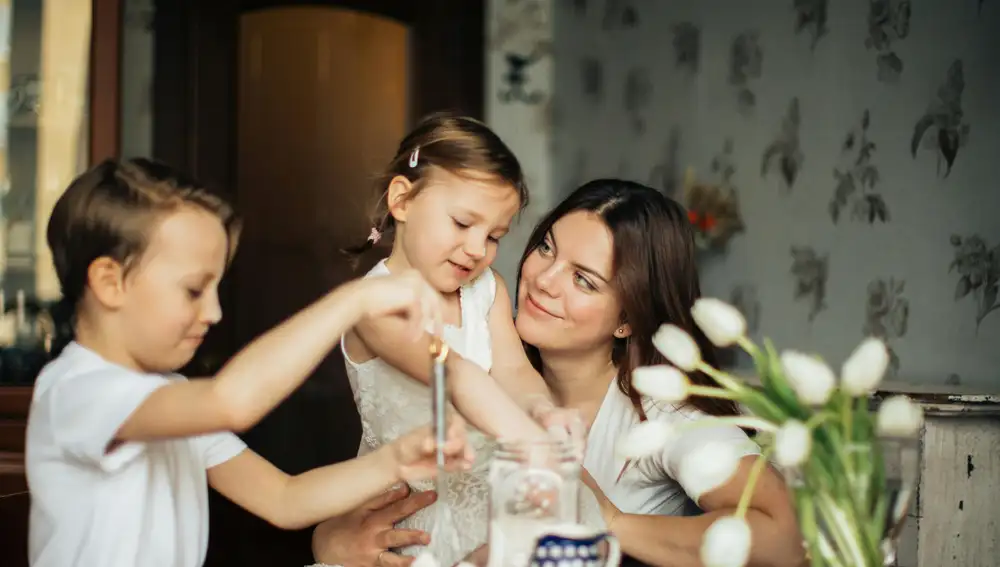Una madre cocina con sus hijo y su hija Una madre cocina con sus hijo y su hija