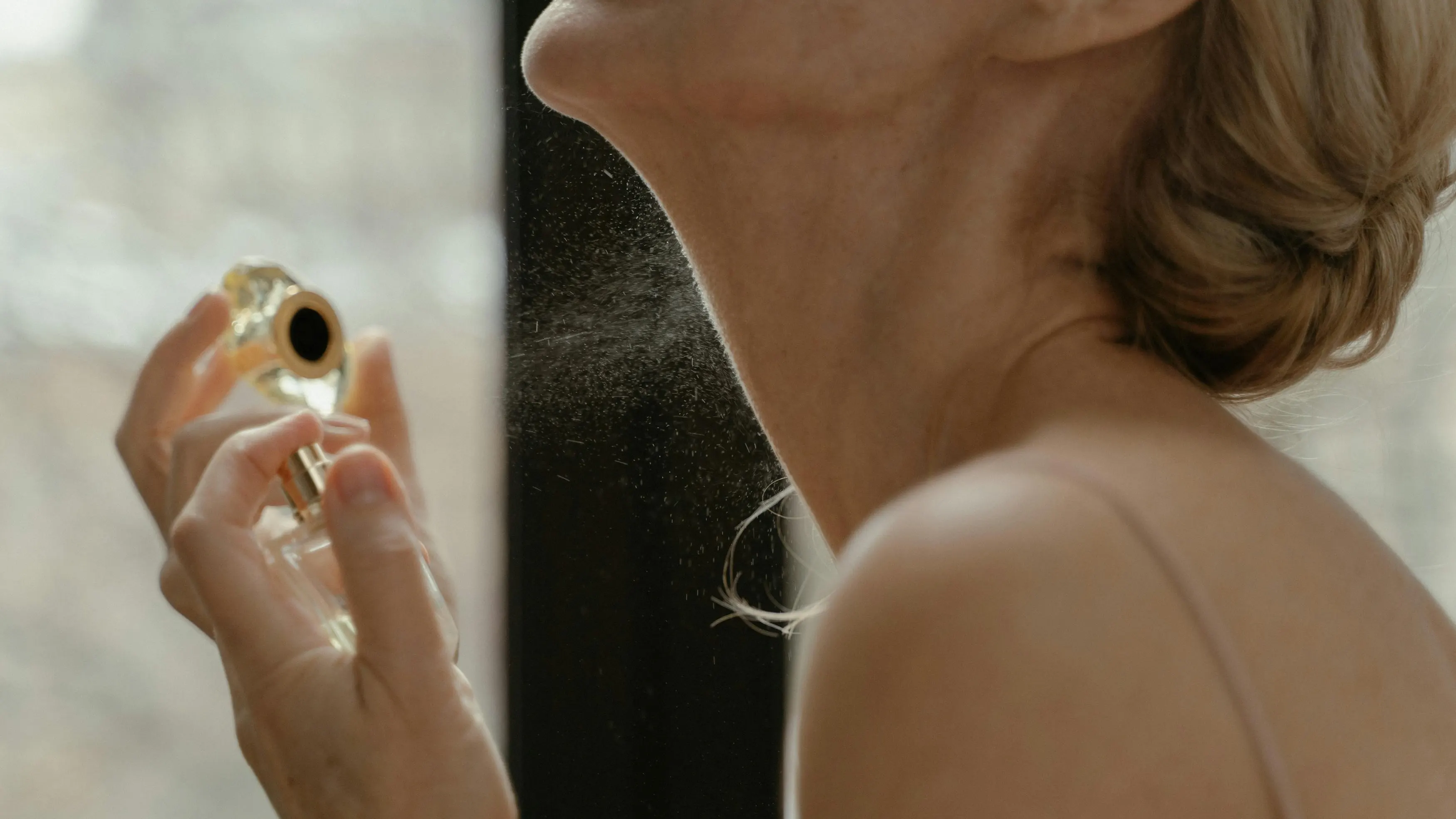 Mujer echándose perfume Mujer echándose perfume