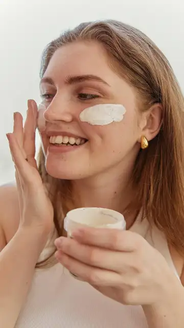 Mujer aplicándose un cosmético Mujer aplicándose un cosmético