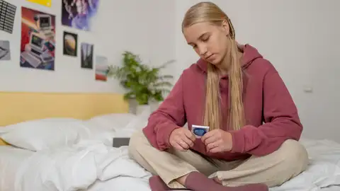 Chica con un preservativo en la mano Chica con un preservativo en la mano