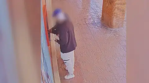 Un ladrón robando a un anciano en el cajero Un ladrón robando a un anciano en el cajero