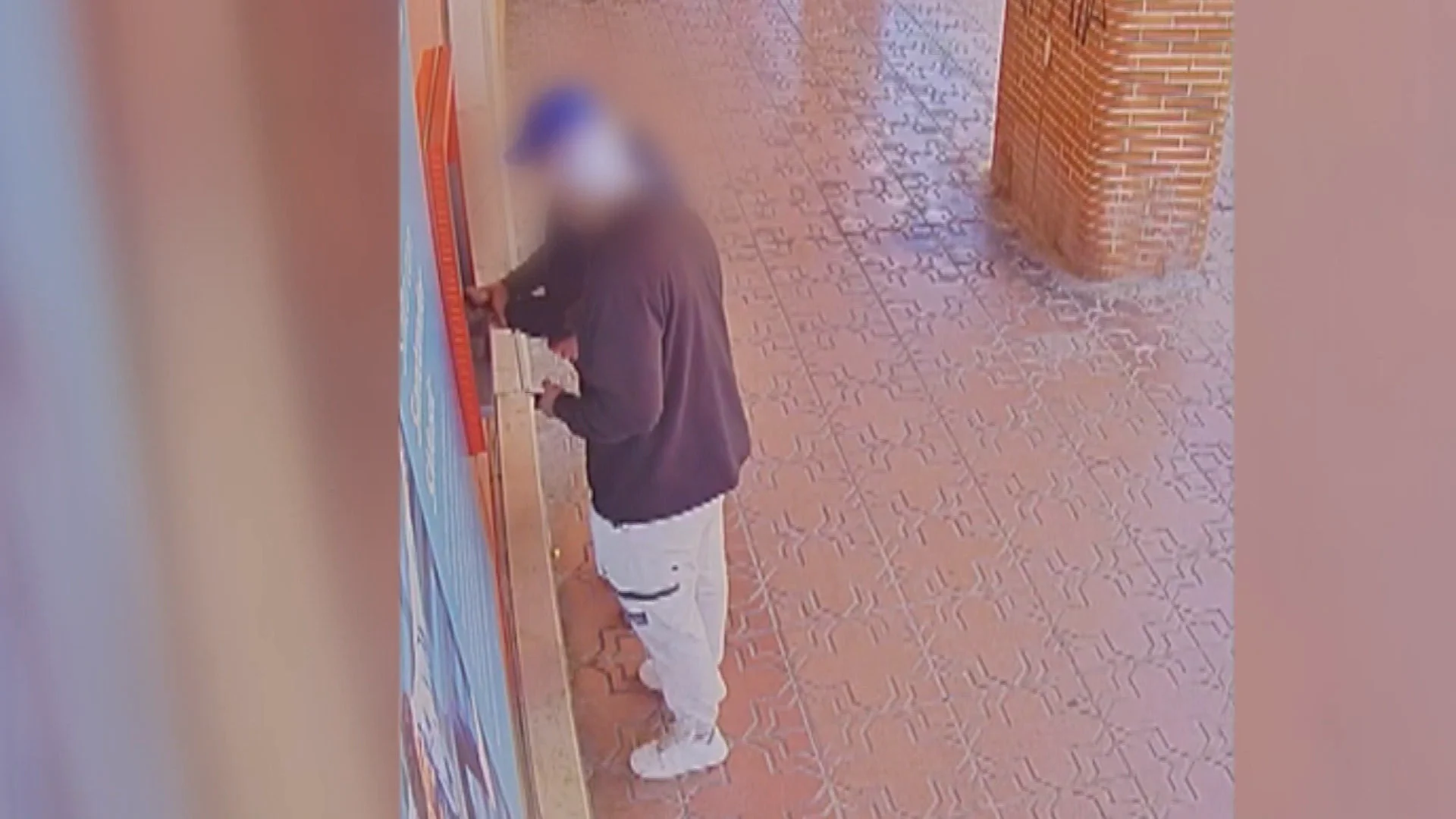 Un ladr&oacute;n robando a un anciano en el cajero