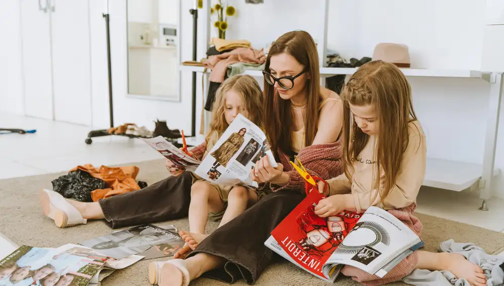 Una madre junto a sus hijas mirando revistas