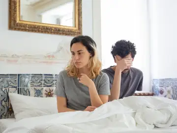 Una pareja en la cama que discute Una pareja en la cama que discute