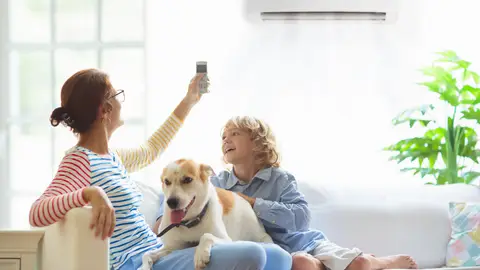 Mujer encendiendo el aire acondicionado