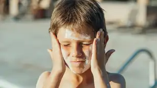 Niño echándose crema solar