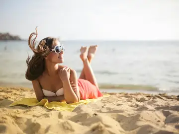 Mujer tomando el sol en la playa Mujer tomando el sol en la playa
