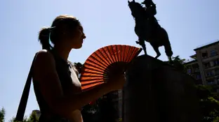 Una mujer se abanica en un día de calor Una mujer se abanica en un día de calor