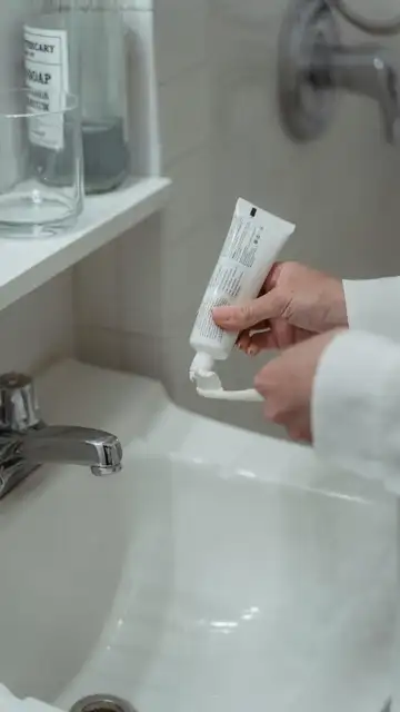 Una persona echando pasta de dientes al cepillo Una persona echando pasta de dientes al cepillo