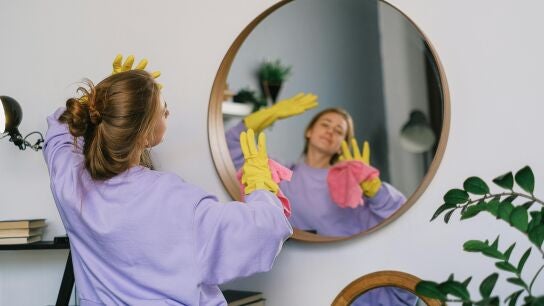 Una persona limpiando la casa con guantes