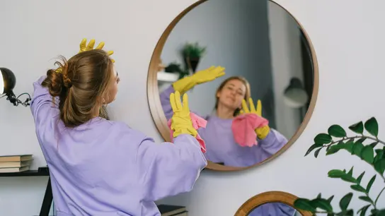 Una persona limpiando la casa con guantes Una persona limpiando la casa con guantes