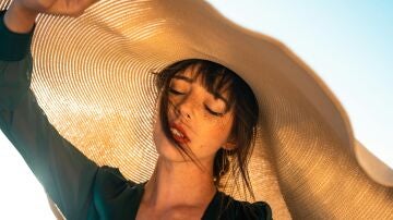 Mujer expuesta al sol y protegida por un gran sombrero