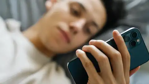 Un chico enganchado al móvil Un chico enganchado al móvil