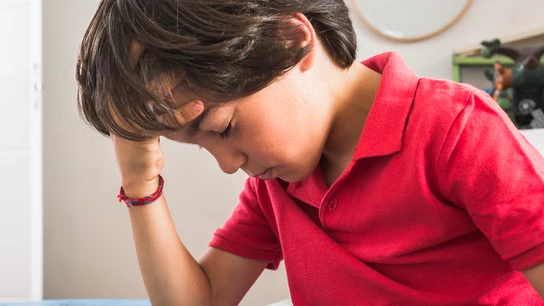 Un niño con dolor de cabeza Un niño con dolor de cabeza