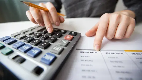 Una mujer usando la calculadora Una mujer usando la calculadora