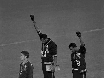 Extending gloved hands skyward in racial protest, U.S. athletes Tommie Smith, center, and John Carlos, stare downward during the playing of the Star Spangled Banner after Smith received the gold and Carlos the bronze for the 200 meter run at the Olympics in Mexico City on Oct. 16, 1968. Australian silver medalist Peter Norman is at left. (AP Photo/files¡¡¡¡¡¡¡OJO FOTO DE COMPRA NO PUBLICAR SIN AUTORIZACION!!!!!!!!!!