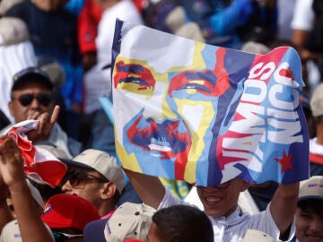 Un simpatizante sostiene un cartel con la imagen del presidente de Venezuela y aspirante a la reelección, Nicolás Maduro, durante el cierre de su campaña
