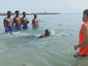 Migrantes aprendiendo a nadar en Canarias