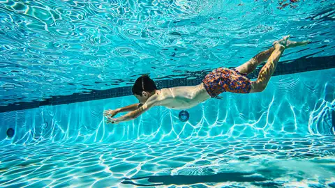 Niño bañándose en la piscina Niño bañándose en la piscina