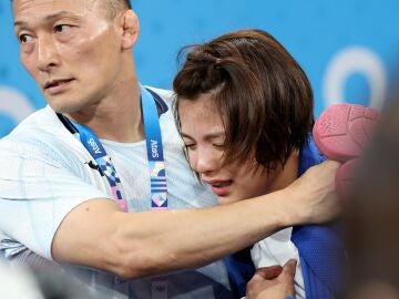 Uta Abe consolada por su entrenado tras quedar eliminada