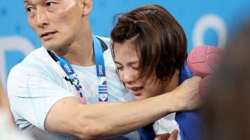 Uta Abe consolada por su entrenado tras quedar eliminada