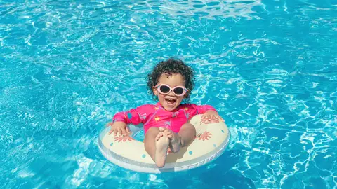 Una niña en una piscina Una niña en una piscina