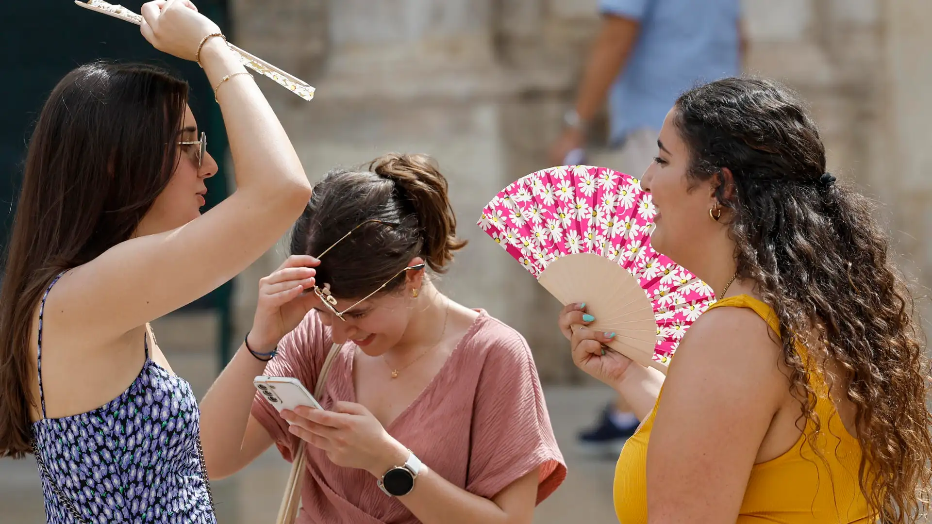 Tres personas protegiéndose del calor Tres personas protegiéndose del calor