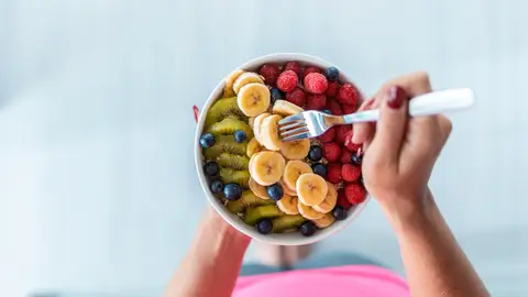 Una persona comiendo un bol de fruta Una persona comiendo un bol de fruta