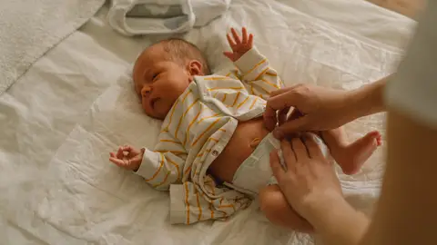 Madre cambiando a un bebé Madre cambiando a un bebé