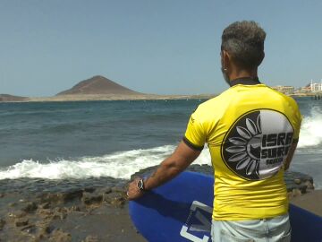 Un surfista mira las olas antes de entrar en el agua