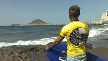 Un surfista mira las olas antes de entrar en el agua